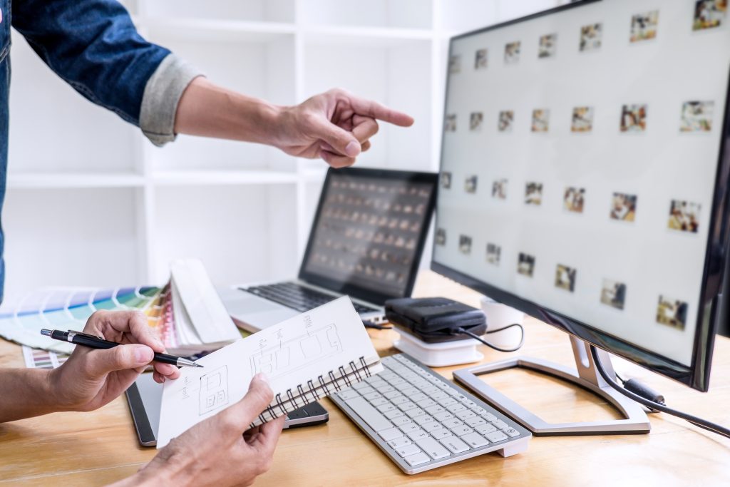 Two colleagues creative graphic designer working on color selection and drawing on graphics tablet at workplace, Color swatch samples chart for selection coloring.